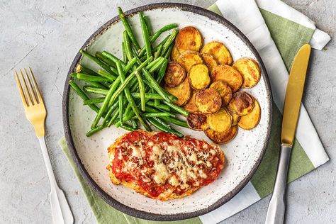 Baked Chicken Parmesan with Crispy Potatoes and Garlicky Green Beans Recipe | HelloFresh Garlicky Green Beans, Tomato Pizza Sauce, Chicken Parmesan Recipe Baked, Chicken Parmesan Recipe, Green Beans Recipe, Seasoned Veggies, Crispy Cheese, Chicken Parmigiana, Hello Fresh Recipes