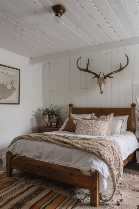 Are you a lover of the great outdoors? Transform your bedroom into a cozy hunting retreat with these rustic decor ideas! Imagine warm wood tones, nature-inspired accents, and unique hunting-themed decor bringing comfort and style together. Perfect for outdoor enthusiasts, you can incorporate fun elements like antler chandeliers and plaid bedding. From wall art featuring wildlife to clever storage that embraces the hunting spirit, discover how to create a personal escape that celebrates your passion for all things rustic and adventurous. Check out these creative ways to bring the hunting vibe home! Deer Skull Above Bed, Antlers Above Bed, Country Western Bedroom Ideas, Outdoors Bedroom Theme, Modern Hunting Decor, Hunting Bedroom Ideas, Hunting Lodge Bedroom, Western Farmhouse Bedroom, Mountain Chic Decor