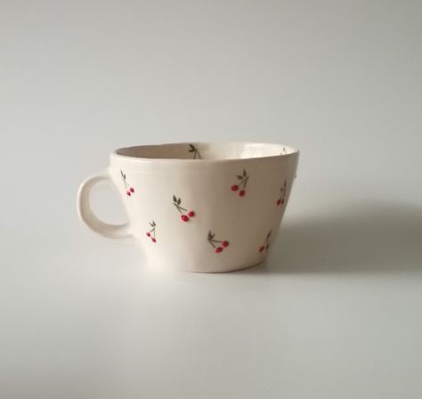 Introducing our exquisite handmade ceramic cup, a testament to craftsmanship and attention to detail. Each cup is meticulously shaped and adorned with a charming, hand-painted tiny cherry motif, adding a touch of whimsy to your daily rituals. Elevate your sipping experience with this unique piece that seamlessly combines functionality with artistic flair. Crafted with care, this cup is a delightful addition to any collection, promising both aesthetic pleasure and practical use. HandmadeCup, CeramicArt, CherryDesign, ArtisanPottery, WhimsicalCup, HandcraftedDrinkware, UniqueCeramics,CherryMotif, FunctionalArt, HomeDecor Kitchenware, ArtisticCup, CollectibleCeramics Painting On Tea Cups, Aestheitc Mug, Cherries Pottery Painting, Cherry Mug Painting, Painting Cups, Cherry Ceramic Mug, Cute Ceramic Mugs Flower, Ceramics Cup, Ceramic Painting Coffee & Tea Cups