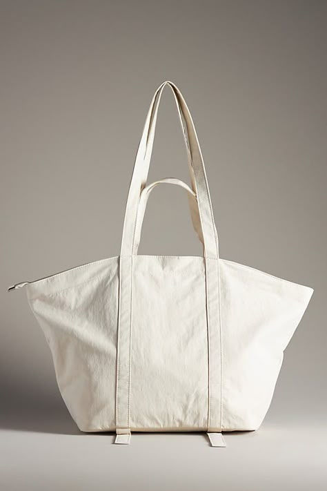 Nylon; polyester lining Features straps for yoga mat on base One inner slip pocket One inner zip pocket Zipper styling Imported | The Dasha Lace-Up Trapeze Tote by Anthropologie in White, Women's, Polyester/Nylon Carry On Tote, Recycled Tote, White Tote Bag, Nylon Tote Bags, White Tote, Sewing Studio, Market Tote, Eco Bag, Nylon Tote