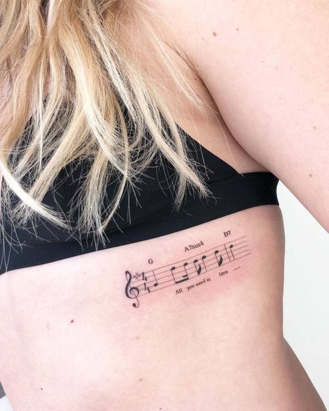 Tattoo of "All you need is love" in musical notes