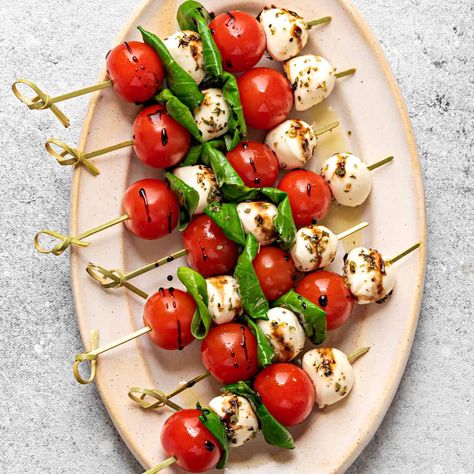 Handy Caprese skewers are a delicious and fun version of a classic Italian salad. This recipe is easy to make with mini tomatoes, mozzarella balls, fresh basil, and a flavorful balsamic reduction. School Lunches For Teachers, Lunches For Teachers, Tomato Mozzarella Skewers, Mozzarella Skewers, Mini Tomatoes, Cheese Skewers, Caprese Salad Skewers, Salad Skewers, Finger Foods Appetizers