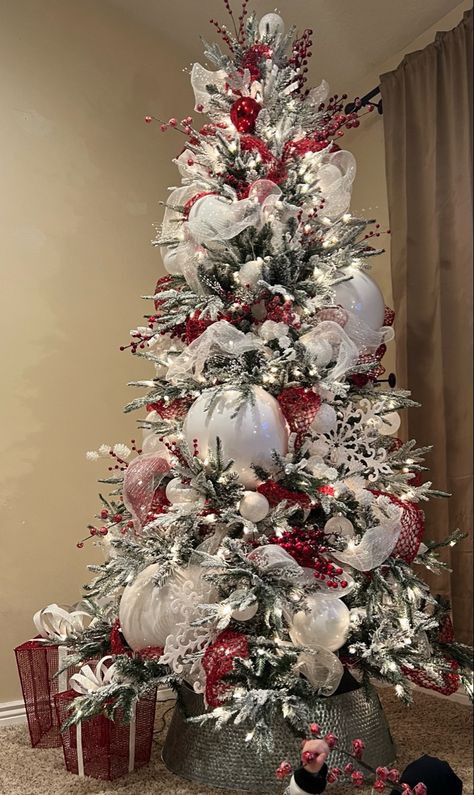 Flocked Christmas tree with large, medium, small ornaments. Red berries, bells, mesh ribbon. White snowflakes, beads, pine cones, ribbon. Red And Grey Christmas Tree, Red White And Silver Christmas Tree Decorating Ideas, Silver White Red Christmas Tree, Red White Silver Christmas Decor, White Silver And Red Christmas Tree, White Gold And Red Christmas Tree, Red And White Christmas Tree Ideas Holiday Decorating, Red White And Silver Christmas Decor, Flocked Tree With Red Decor