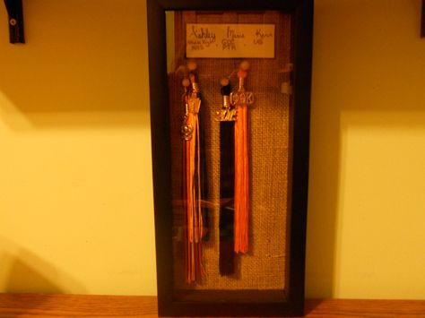 I wanted to display my graduation tassels (and future ones to come) somewhat creatively. Using double-sided tape I stuck burlap to the inside of a shadow-box frame, then used decorative pushpins (secured by hot glue) to hang my tassels, with the loops cut off. The burlap was a bit challenging to work with, but I'm happy with the results! :) Graduation Tassel Display, Cap Quotes, Graduation Display, Shadow Box Ideas, Graduation Tassel, Cash Gift, Grad Cap, Graduation Ideas, Grad Party