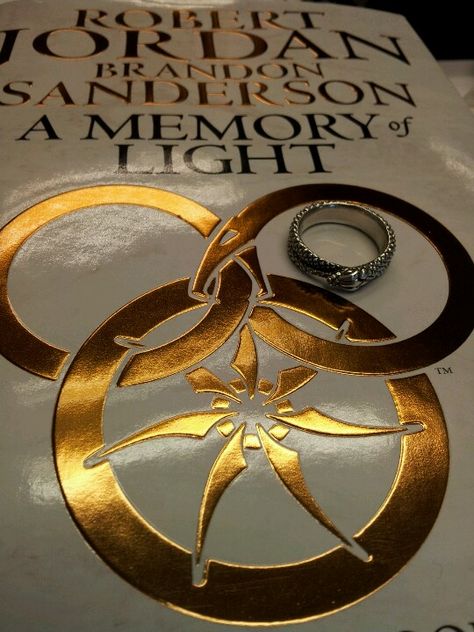 THE new book...accompanied by my aes sedai ring! (which they dont make in gold, btw) Aes Sedai Ring, Wheel Of Time Aes Sedai Ring, Wheel Of Time Yellow Ajah, Wheel Of Time One Power, Tarot Of The Golden Wheel, Aes Sedai, Wheel Of Time Books, Robert Jordan, Wheel Of Time