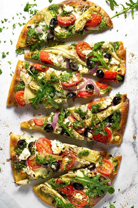 This Mediterranean Flatbread pizza is the perfect quick and easy vegetarian dinner for a busy weeknight! My 5 Minute Flatbread crust creates a crispy, crunchy base that is topped with homemade spinach pesto, mozzarella, feta, artichoke hearts, red onion, grape tomatoes, and black olives. Mediterranean Flatbread Pizza, Quick And Easy Flatbread Recipe, Greek Flatbread Pizza, Feta Artichoke, Greek Flatbread, Mediterranean Flatbread, Easy Flatbread Recipes, Pesto Mozzarella, Sweet Pizza