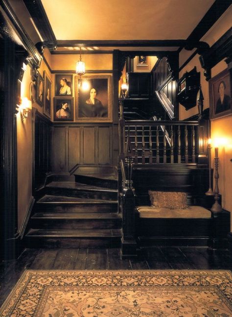 For the late-1990s film “Practical Magic,” the decidedly A-list design duo Roman and Williams built and decorated a Victorian-inspired home. The home’s dark, candlelit interiors were modeled on East Coast lighthouses — and perfectly suited to host a coven of fictional witches. | I love the black paneling and cozy feel of the space! Dark Wood Cottage, Victorian Staircase, Dark And Moody Interiors, Practical Magic House, Cer Nocturn, Magic House, Moody Interiors, Stair Case, I'm Crazy