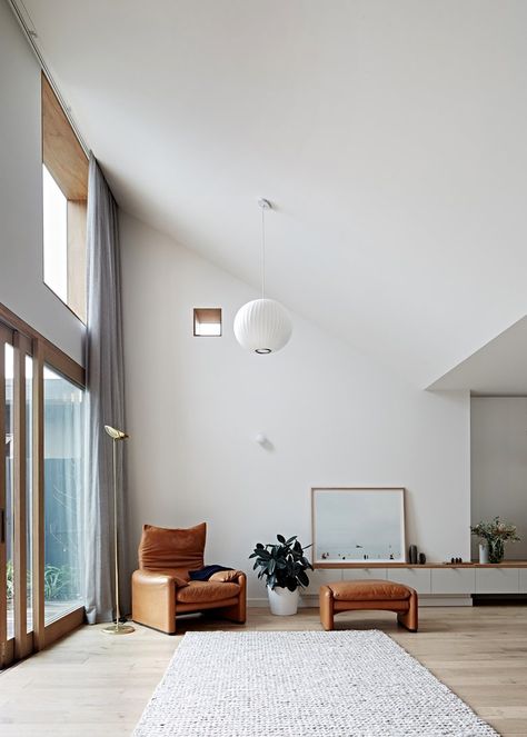 A dramatic raked ceiling and large clerestory window at Hoddle House by Freadman White Architects creates an inspiring, light-filled space. Sliding glass doors mean the room connects seamlessly to the yard. Photo by Jeremy Wright. Black Brick House, Interior Minimalista, Melbourne House, Minimalism Interior, A Living Room, Lounge Room, New Room, 인테리어 디자인, White Walls