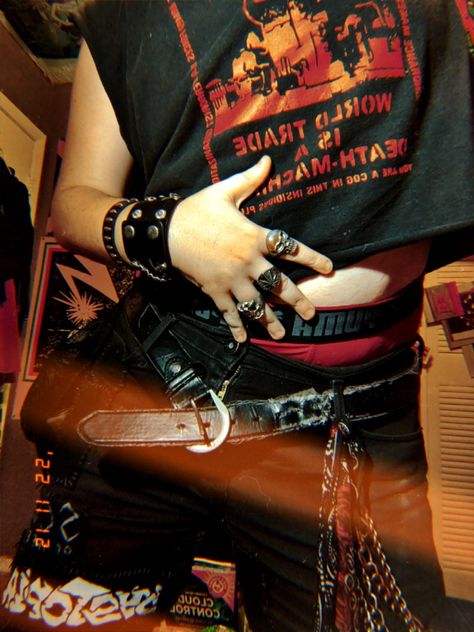 Punk guy, leftover crack shirt reading "world trade is a death machine", red lettering on black, patches on his left thigh reading "dystopia" and "scum of the earth", 3 rings on his hand, 2 leather bracelets, wallet chain and bandana hanging on his right ride. Punk Band Outfits, Queer Punk Aesthetic, Trans Punk Aesthetic, Punk Lace Code, Punk Transmasc, Knox Aesthetic, Punk Boy Aesthetic, 2000s Pop Punk Aesthetic, Crust Punk Aesthetic