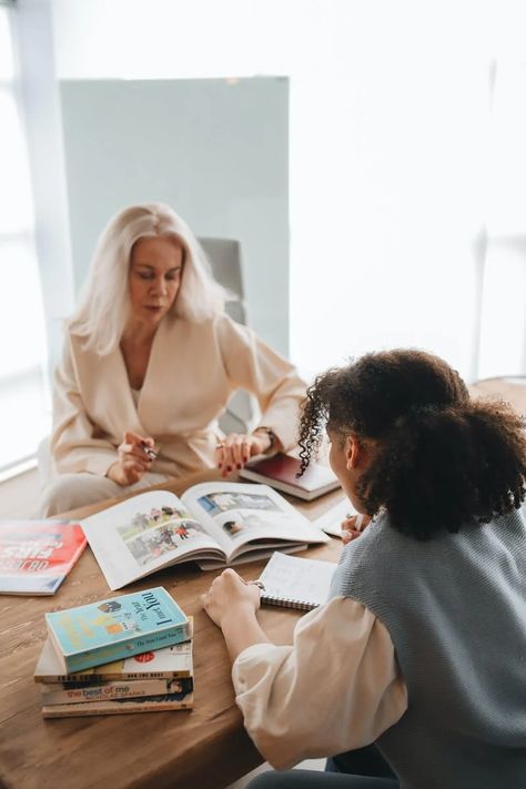 Teacher Pointing the Pictures in a Book · Free Stock Photo Preschool Branding, Coaching Photoshoot, Women Studying, Education Aesthetic, Studying Together, Surrounded By Books, Campaign Strategy, Teacher Lifestyle, Coach Branding