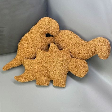 Features: Meet your new favorite and tastiest plushies, the Ultra Soft Dino-Nuggets Plush Pillows! The most perfect and cutest mix between widely beloved chicken nuggets and adorable dinosaurs. Choose your favorite dinosaur plushie to cuddle with today or collect them all! Crafted from high-quality and soft cotton materials, these pillows are both durable and comfortable, so you can cuddle and squish them for years to come. The perfect gift for your loved ones or for yourself as a little splurge Dino Nuggie Pillow, Dino Nuggets Pillow, Quirky Pillows, Nuggets Aesthetic, Weird Plushies, Dino Nugget Pillow, Giant Plushies, Funny Plushies, Unique House Decor