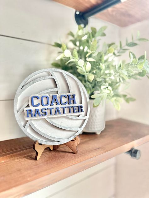 This personalized desktop volleyball coach sign is the perfect gift for  your volleyball coach! This sign is 6" x 6" inches round made with 1/4 inch wood and 1/4 wood cut out letters. Each Volleyball comes with a stand perfect to sit on your favorite coaches desk  and can be made in custom school or team colors.  These make great gifts for  end of year gifts, Christmas or back to school!  We make every sign out of real wood - because of this each sign will be unique and have its own variation of Wood Volleyball Sign, Volleyball Banquet Gifts, Gift For Volleyball Coach, Gifts For Volleyball Coaches, Volleyball Gifts For Coach, Volleyball Party Favors, Volleyball Decor, Gifts For Coaches, Coaches Gifts