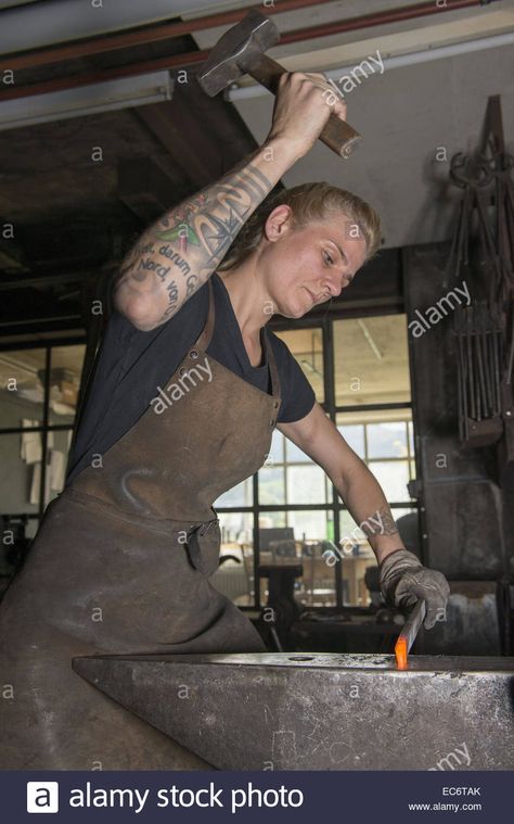 Download this stock image: female blacksmith working at ambos with hammer on redhot steel - EC6TAK from Alamy's library of millions of high resolution stock photos, illustrations and vectors. Blacksmith Pose Reference, Blacksmith Pose, Blacksmith Reference, Blacksmith Woman, Blacksmith Aesthetic, Woman Blacksmith, Female Blacksmith, Medieval Blacksmith, Diy Forge