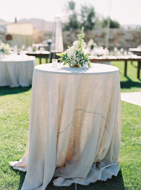 La Tavola Fine Linen Rental: Tuscany Natural | Photography: Kelsea Holder Photography, Coordination: Danae Grace Events & Design, Florals: Anna Le Pley Taylor, Venue: Sunstone Vineyards & Winery, Rentals: Central Coast Tent & Party Cocktail Table Ideas, Cocktail Table Florals, Wedding Cocktail Table, Outdoor Wedding Bar Table, Cocktail Hour Tables, Ivory Wedding Linens Tablecloths, Ivory Linen Wedding Table, Cocktail Tables Wedding, White Linen Round Table Wedding