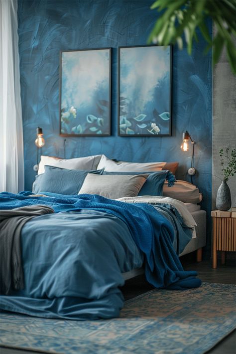 Oceanic Serenity • Wrapped in shades of the sea, the bedroom offers a tranquil retreat, with a wall of artful blue textures setting a dreamy backdrop • Layers of cerulean and sapphire textiles adorn the bed, mirroring the ocean's depth • A pair of serene seascapes grace the wall, echoing the watery hues • Warm, ambient light from minimalist sconces casts a gentle glow, akin to a coastal sunset • Accents of natural wood and a leafy houseplant infuse the room with an earthy balance Forest And Ocean Bedroom, Earthy Bedroom Blue, Blue Aesthetic Home Decor, Bedroom Blue Aesthetic, Cozy Bedroom Blue, Calm Bedroom Aesthetic Blue, Blue Aesthetic Home, Blue Ocean Bedroom Aesthetic, Bedroom In Blue