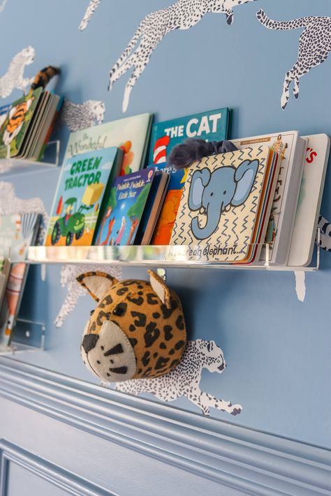 closeup of acrylic shelves with books in adventure themed nursery with leopard wallpaper Cool Boy Nursery, Colorful Boy Nursery, Shelves With Books, Adventure Themed Nursery, Toddlers Bedroom, Kids Bedroom Wallpaper, Acrylic Shelves, Adventure Theme Nursery, Nursery Planning