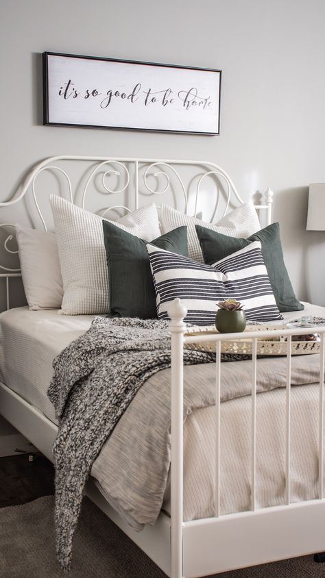 White & Grey Bedroom. Bedroom designed and styled with Ikea bedframe, toss cushions, & linens. Cozy and modern, great for a guest bedroom. Wall colour is Benjamin Moore Gray Owl. Airdrie, AB, Rocky View County, AB. eDesign. Leirvik Bedframe. #bedroomstyling #bedroomdesign #whitebedframe #ikeacanada #sparebedroomdecor #greendecor #grayowl #whtietosscushions #whitepillows #blackandwhite #blackandgrey #whiteandgrey #whiteandgreybedroom #whiteandgreenbedroom #greyandgreenbedroom #whitegreygreen Ikea Bedframe, Ikea Metal Bed, Ikea Bedroom Ideas For Couples, White Grey Bedroom, Ikea Style Bedroom, Grey Green Bedrooms, Benjamin Moore Gray Owl, Leirvik Bed, White Iron Beds