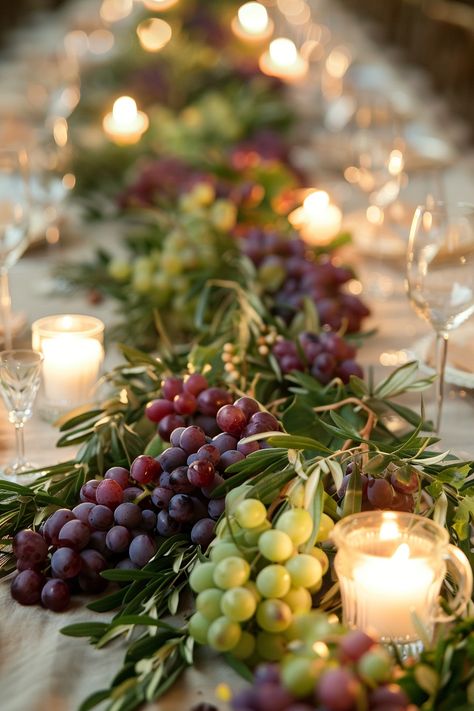 ✨ Elevate your wedding ambiance with a centerpiece that whisks you away to the rolling hills of Tuscany. Experience the charm of Italy as grape vines & olive branches intertwine with the warm glow of candles on your special day. #WeddingInspiration #TuscanWedding #RomanticDecor #WeddingIdeas #CountryChic #RusticElegance #GrapeAndOlive #CandlelightMagic Let the light guide your love story. Olive Flower Arrangement, Tuscan Themed Wedding Reception, Grapes On Wedding Table, Grape Decorations Party, Bread Wedding Centerpieces, Tuscany Table Decor, Grape Centerpiece Wedding, Olive Branches Decor, Tuscan Vineyard Wedding