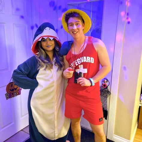 Onsie Costume Couple, Shark And Life Guard Costume, Shark And Surfer Costume, Shark Onesie Halloween Costumes, Shark Couple Costume, Onsie Couples Costumes, Shark And Lifeguard Costume Couple, Couple Onsies Costumes, Lifeguard And Shark Costume