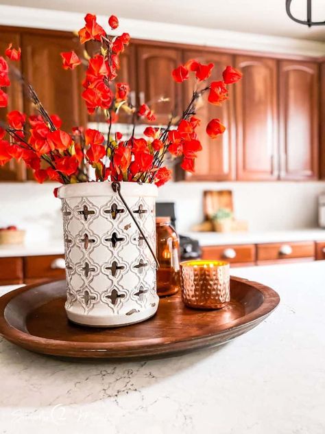 Who says a kitchen with cherry cabinets can't look modern? We've got ideas to update your kitchen with wood cabinets without painting them! This kitchen update includes a custom island with paneling and table legs. New pendant lights over the island add curves and style. Rattan counter stools add texture. White dovestone quartz counters really brighten the room. The matte white lantern tiles or arabesque tiles with white grout gives a light and bright feel. You'll love the fall decor ideas too! Fall Kitchen Island, Fall Kitchen Island Decor, Cherry Kitchen Island, Kitchen With Wood Cabinets, Cherry Wood Kitchen, Kitchen With Cherry Cabinets, White Subway Tiles Kitchen Backsplash, Cherry Kitchen Decor, Arabesque Tiles