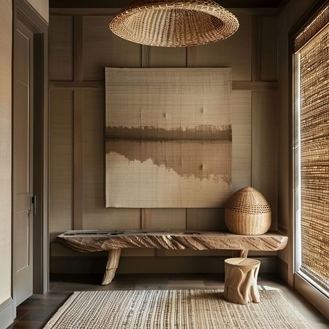 Luxurious wabi-sabi foyer featuring natural wood accents, textured walls with wood panelling, a large abstract wall art in muted tones, and a woven bench under a rattan pendant light. Earthy and neutral tones enhance the minimalistic aesthetic, complemented by natural lighting and a large textured rug, perfect for a serene entryway. Wabi Sabi Foyer, Wabi Sabi Entryway, Wabi Sabi Hotel, Wabi Sabi Bench, Large Abstract Wall Art, Rattan Pendant Light, Room Types, House Room, Wood Accents