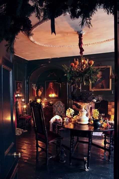 a Gothic dining room with black walls and a floor, a round table, chairs, artworks, candles and a fireplace Gothic Dining Room, Goth Houses, Witchy House, Gothic Kitchen, Dark Home Decor, Goth Home, Goth Home Decor, Dark Home, Dark Interiors