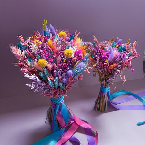 Introducing our Vibrant Dried Flower Bouquet, a top-seller renowned for its stunning array of colors, primarily featuring rich shades of purple, blue, and pink with berry undertones. This bouquet is an ideal choice for couples seeking a bohemian, whimsical, or LGBTQ+ pride-themed wedding, as well as those embracing a bright and colorful wedding palette. 🌈 Our bouquet showcases a lively assortment of premium dried flowers carefully selected and artfully arranged to create a breathtaking visual d Nontraditional Bouquet Wedding, Creative Wedding Bouquets, Color Wedding Bouquets, Blue And Purple Wedding Flowers, Rainbow Wedding Centerpieces, Rainbow Flower Bouquet, Colorful Wedding Palette, Wedding Bouquets Colorful, Rainbow Bridesmaids