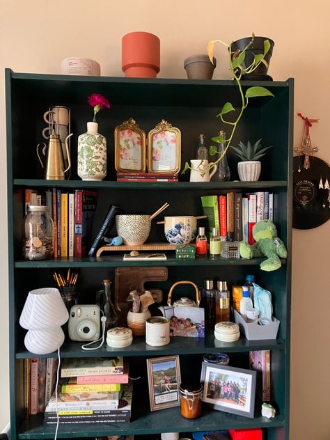 Green Book Shelf with lots of books,jars,plants, and pictures Shelf Decor Living Room Maximalist, Cluttered Shelf Aesthetic, Maximalist Shelf Styling, Bookshelf Maximalist, Maximalist Bookshelf Styling, Trinket Bookshelf, Maximalist Shelves, Maximalist Organization, Maximalist Shelf Decor