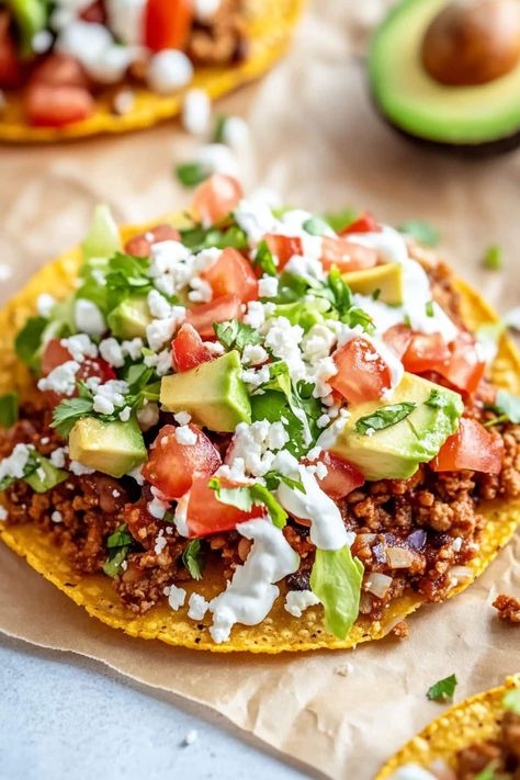 These easy Mexican tostadas are the perfect addition to any fiesta! Made with ground beef, refried beans, lettuce, tomato, cheese, and toppings, they're just too good! Beef Tostadas Ground, Tostada Salad Bowl, Ground Beef Tostada Recipes, Ground Beef Tostadas, Ground Beef Refried Beans, Mexican Tostadas, Beef Tostadas, Tostada Recipes, Refried Beans Recipe