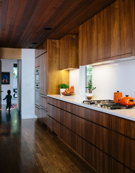 In the kitchen, interior designer Emily Knudsen Leland replaced purple laminate cabinets with flat-sawn eastern walnut, and added PentalQuartz countertops in polished Super White for contrast. The cooktop and oven are from Miele. Walnut Kitchen Cabinets, Modern Kitchen Renovation, Wooden Kitchen Cabinets, Walnut Kitchen, Mid Century Modern Kitchen, New Kitchen Cabinets, Kitchen Cabinets Makeover, Wood Kitchen Cabinets, Modern Kitchen Cabinets