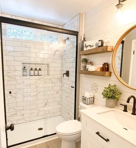 A clear glass panel door exposes the bright white modern wall tiles within this small bathroom shower. The rectangular subway style of the marble tiling gives it a unique flare and a modern finish that goes well with the black fixtures, gold framed mirror, and white shiplap walls...   Image: doodledream.life Modern Wall Tiles, Small Farmhouse Bathroom, Walk In Shower Ideas, Beautiful Small Bathrooms, Black Painted Walls, Black Fixtures, Small Bathroom With Shower, Subway Style, White Shiplap Wall