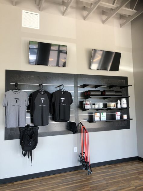 This display takes up a good amount of wall space, but still leaves room above and below for other props and fixtures to be placed around it. Slate Wall Display Retail, Merchandise Wall Display Ideas, Merch Wall Display, Retail Wall Display Ideas, Product Display Wall, Retail Wall Displays, Jiu Jitsu Gym, Physio Clinic, Skirt Shapes