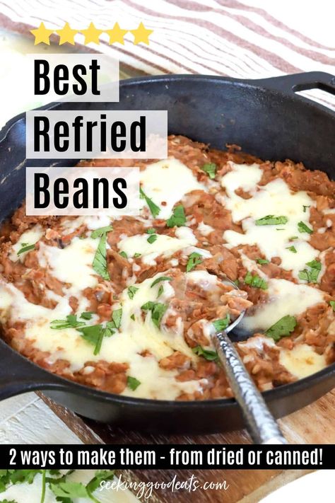 A cast iron skillet of refried beans with cheese and cilantro The Best Refried Beans, Mexican Burritos Authentic, Improve Canned Refried Beans, Refried Beans With Cheese, Refried Beans Tostadas, Restraunt Style Refried Beans, Homemade Refried Beans Recipe, Refried Bean Side Dish, Refried Beans Restaurant Style