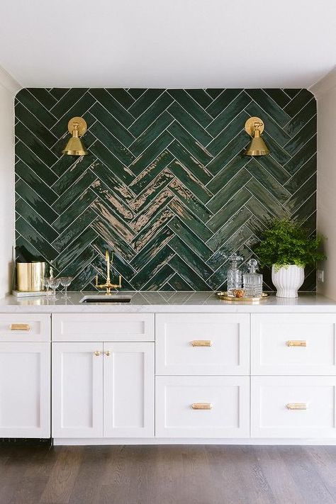 Contemporary white wet bar accented with glossy green herringbone backsplash tiles and white and gray quartzite countertops boasting an antique brass vintage bar faucet. White Wet Bar, Green Tile Backsplash, Kitchen With White Cabinets, Bar Deco, Green Backsplash, Herringbone Backsplash, Ideas Hogar, Club Ideas, Contemporary Dining Room