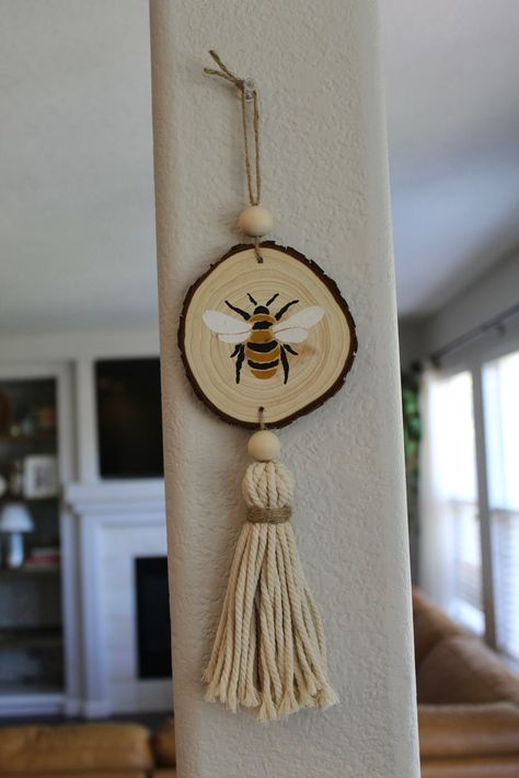 Beautiful hand painted bumblebee on a natural wood slice. This ornament can add a lovely touch to any space. Can be used as a wall ornament, tree ornament, or a rearview mirror ornament. This piece is hand painted and adorned with a beautiful macrame tassel and natural beads. Perfect for any bee lover! Wood Burned Gift Ideas, Wood Slice Craft Ideas, Wood Slice Art Diy, Wood Round Crafts, Wood Ornaments Diy Tree Slices, Wood Circle Crafts, Wood Bead Crafts, Wood Slices Crafts, Wood Slice Diy