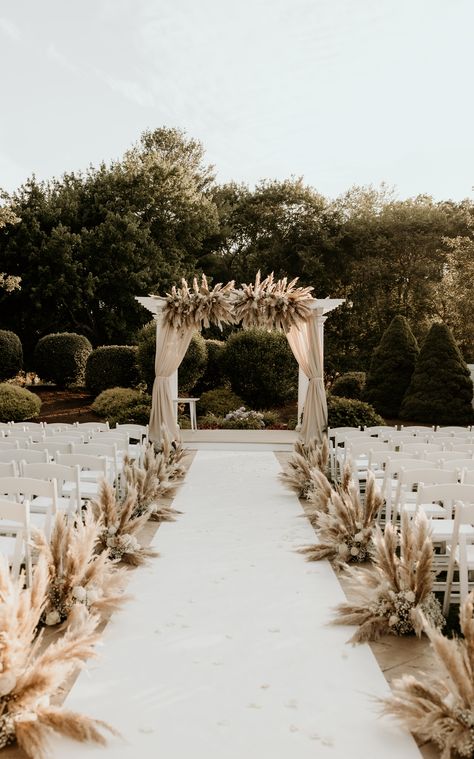 We're obsessed with this pampas grass wedding decor featuring arch draping, an aisle runner, and aisle decor. | Photography: Cami P Photography Pampas Grass Wedding Ceremony Aisle, Pampas Chair Decoration, Pampas Down The Aisle, Pampas Grass Isle Wedding Decor, Wedding Ceremony Runner, Pampas Grass Wedding Aisle Decor, Pampas Grass Wedding Decor Isle, Outdoor Wedding Aisle Ideas Boho, Wedding Arch Ideas Pampas