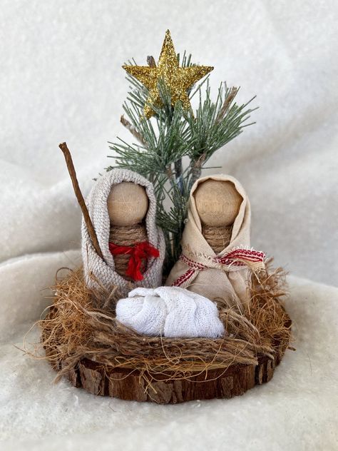 "Celebrate the true meaning of Christmas with this wood nativity set. This will fit on most trays, shelves, risers, mantles or any small spaces. The base is a wood slice and Mary and Joseph are made of wood pegs that I wrapped in jute. Baby Jesus is made from a wood bead and swaddled in soft fabric.  measurements: 5\" x 4\" x 4\"" Wine Cork Nativity Scene, Scrap Wood Nativity, Wood Peg Nativity, Wooden Nativity Sets Diy, Advent Decorations Diy, Nativity Diy Crafts, Nativity Tablescape, Christmas Manger Ideas, Wood Nativity Diy