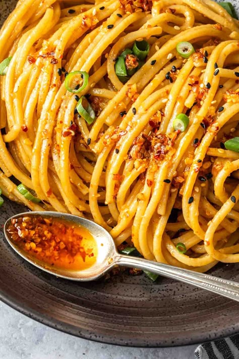 Chili garlic noodles are a spicy and sweet delight. This simple dish is made with a soy-ginger peanut sauce seasoned with chili crisp then stir fried with your favorite pasta. Garnish with sesame seeds and green onions for an additional crispy crunch. Chili Onion Crunch Pasta, Spicy Chili Crisp Noodles, Chilli Crisp Noodles, Chili Crunch Noodles, Recipes With Chili Crunch Oil, Chili Crisp Pasta, Trader Joes Chili Onion Crunch Recipes, Chili Crunch Oil Uses, Chili Crisp Uses