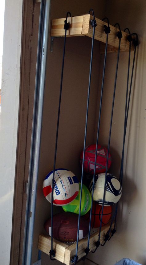 Ball storage for garage using bungee cords.  My husband finished it recently.  He said he wished he would have used thinner wood.  He stated it would have been easier to hook the bungee cords into it.  The wood he used ended up being too thick so he had to drill holes for the cords--- this works because the cords don't slide back and forth, but drilling into the wood was time consuming, he said. Thanks hon! Storage For Garage, Diy Storage Projects, Garage Storage Inspiration, Garage Organisation, Diy Toy Storage, Feather Wall Decor, Garage Storage Solutions, Garage Organization Diy, Garage Organize