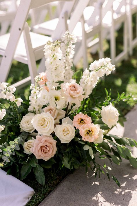 soft pink and white aisle floral arrangement #socalweddingplanner #timelessweddingcolors White Ground Floral Arrangement, 2025 Wedding Aesthetic, White Ceremony Chairs, Pink And White Wedding Florals, Wedding Pergola Flowers, Floral Aisle Wedding, Wedding Aisle Flowers On Ground, Church Flowers Wedding, Flower Walkway