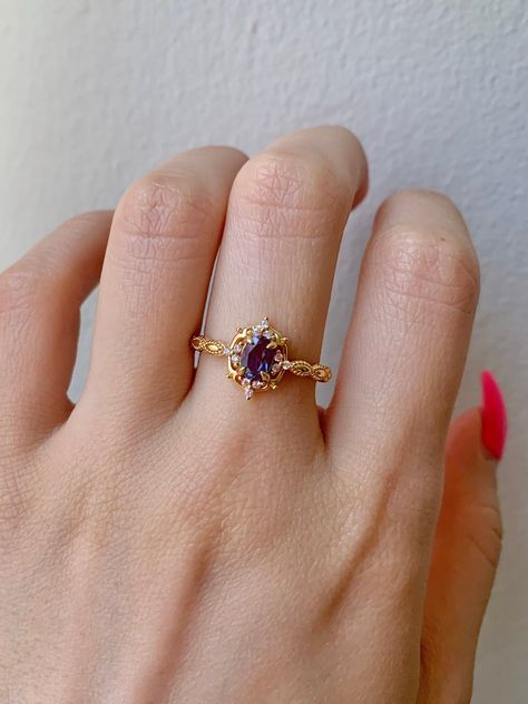 Gorgeous vintage inspired Alexandrite ring ✧ Sterling silver (925) or 14K Gold or 14K Rose gold ✧ Accented with natural quartz diamonds This gorgeous, timeless ring features a stunning alexandrite and natural crystals. ✧ Shape: Oval ✧ Color: Purple/maroon/purple (color changes in different lighting) ✧ Carat Weight: 0.53ct.(approx.) ✧ Gemstone Origin: Brazil ✧ Sizes 3.75-11.25 ✧ This ring set will arrive ready to gift in a Kherish Box. ✧ Due to the nature of the handmade process, each piece may s Alexandrite Promise Ring, Tangled Promise Ring, Purple Crystal Ring, Vintage Amethyst Ring, Vintage Alexandrite Ring, Crystal Rings Engagement, Two Stone Ring, Gemstone Ring, Purple Engagement Ring