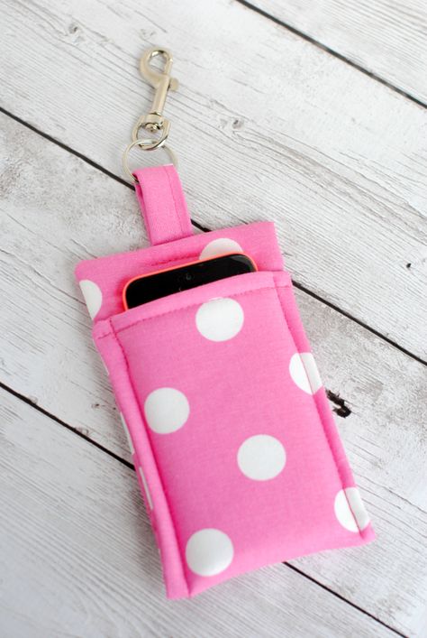 Make this quick and Simple DIY Phone Wallet to carry your phone wherever you go. This tutorial is super simple and should take less than 30 minutes to complete. It's a great project for beginners! Make one of these cute phone cases with a few scraps of fabric and fusible fleece, and attach a clasp so you can clip it to your purse or key chain. If you've been looking for patterns for fabric phone cases, you'll love this adorable, pink, polka-dotted design! Get out your sewing machine and whip up Tips Menjahit, Sew Wallet, Wallet Tutorial, Scrap Fabric Projects, Costura Diy, Leftover Fabric, Cell Phone Case, Sewing Projects For Beginners, Diy Couture