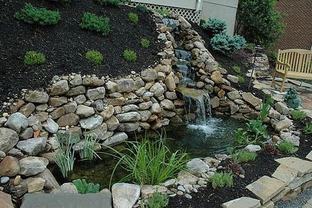 How to Build a Water Garden with a Waterfall on a Hillside thumbnail Small Waterfall Pond, Pond Landscaping Ideas, Ponds Backyard Waterfall, Waterfall Pond, Affordable Backyard Ideas, Building A Pond, Fountains Backyard, Garden Waterfall, Pond Landscaping