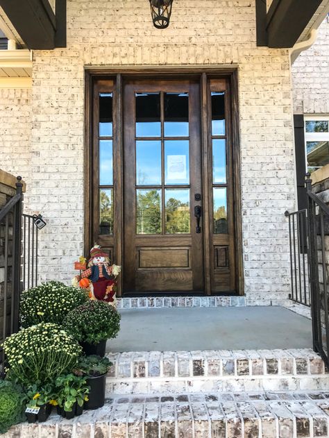 White brick, dark trim and stone set this Parade Home apart Exterior Brick Treatments, White Brick House Brown Trim, Light Brick With Dark Trim Exterior, Aspen Ridge Brick, White House Dark Brown Trim Exterior, Brick Around Front Door, Light Brick House Exterior Dark Trim, Brick Ideas For House Exterior, White Brick With Black Trim