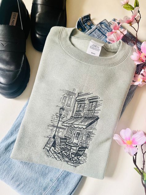 Cozy up in our . Perfect for a day out exploring the city or a night in with friends. #CozyCrewneck #CityCafe . #Cute_Embroidery_Designs_Sweatshirts #Crewneck_Design_Ideas #Cafe_Merch #Unique_Embroidery_Designs Cute Embroidery Designs Sweatshirts, Embroidery Tshirt Designs, Embroidery Tee Shirts, Crewneck Design Ideas, Cafe Merch, Clothes With Quotes, City Cafe, Graphic Shirt Design, Embroidery Tshirt