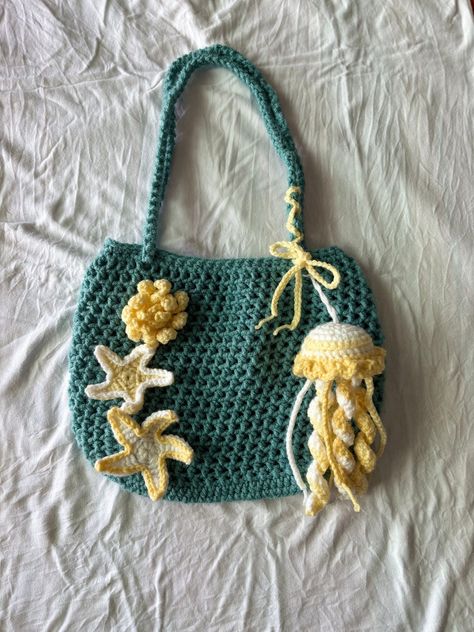 -Handmade crochet ocean-themed crochet bag -includes starfish motifs and a jellyfish keychain -Lined with satin -convertible lengths - a simple and fast project..#crochetbag #handmadebag #DIYbag #crochetlove #bagaddict Crochet Ideas Pictures, Crochet Projects Thick Yarn, Ocean Crochet Ideas, Crochet Ocean Bag, Crochet Bag Accessories, Starfish Crochet, Diy Starfish, Ocean Crochet, Crochet Ocean