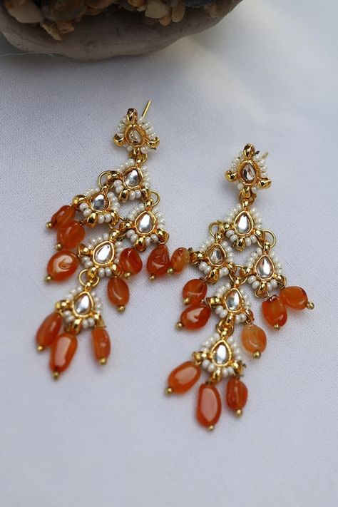 Gold plated dangler earrings with kundan embellishment, pearl highlights on the edge and orange stone drops. Type: Stone and Kundan Composition: Silver Alloy Color: Orange Other Details:  Dimension L x B (in cms): 6 x 2.5 Weight (in gms): 25 Closure: Push back clasp  - Aza Fashions Pearl Highlights, Jayanti Reddy, Orange Saree, Diana Penty, Dangler Earrings, Orange Stone, Earring Collection, Luxury Sale, Kundan Earrings