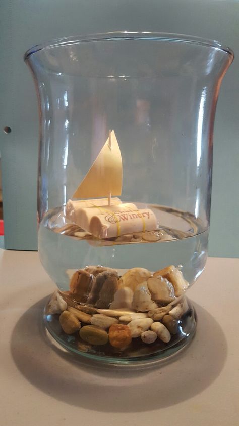 Cork boats! Centerpieces for my wedding! 3 corks 2 Ouchless rubber bands 1 Toothpick Paper Rocks in the bottomof a vase with water Super easy and REALLY cheap! Ship Centerpiece Ideas, Sailor Centerpieces, Cruise Centerpieces Table Decorations, Nautical Flower Centerpieces, Sailboat Centerpiece Ideas, Boat Centerpiece Ideas, Wave Centerpiece, Nautical Table Centerpieces, Nautical Centerpiece Ideas