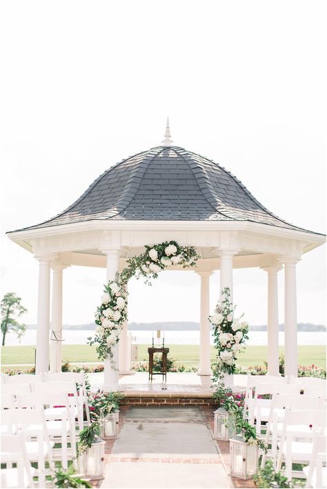 A stunning ceremony site overlooking the water in Williamsburg, Virginia. Floral arch, lanterns lining the ceremony chairs made for a romantic and elegant ceremony site. Two Rivers Country Club Gazebo Wedding Ceremony, Gazebo Wedding Decorations, Gazebo Decorations, Sweetheart Table Wedding, Ceremony Chairs, Navy Uniforms, Gazebo Wedding, Wedding Photography Business, Williamsburg Virginia