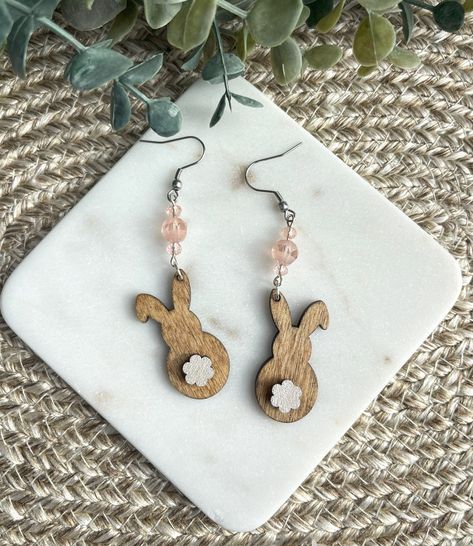 Introducing our adorable Boho Bunny Earrings with a cute cotton tail and delightful pink beads! The intricate design features a playful bunny with a Wood cotton tail, adding a touch of charm to your look. The delicate pink beads lend a pop of color and add a feminine touch to these earrings. Handcrafted with love and attention to detail, these Boho Bunny Earrings are the perfect accessory for Easter. Earrings are made from  1/8" Birch wood beautifully Stained with hand painted wood cotton tail. The beautiful Pink Beads really set these earrings off! Earrings are approximately 2.50inches long, .75 inches wide with a drop length of 3 inches. Ear Wires are Stainless Steel. Earrings are Light Weight. Please visit our shop to view our collection of Gorgeous Handcrafted Earrings https://artisanm Acrylic Keychain Ideas, Laser Earrings, Boho Bunny, Diy Laser Engraver, Laser Engraved Earrings, Laser Cut Projects, Engraving Projects, Laser Engraving Ideas, Glowforge Projects